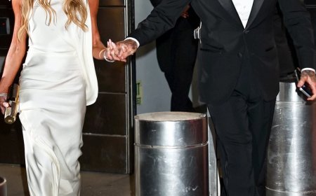 Victoria Beckham cuts an elegant display in a silk gown as she and husband David hold hands outside the TIME100 Gala in New York