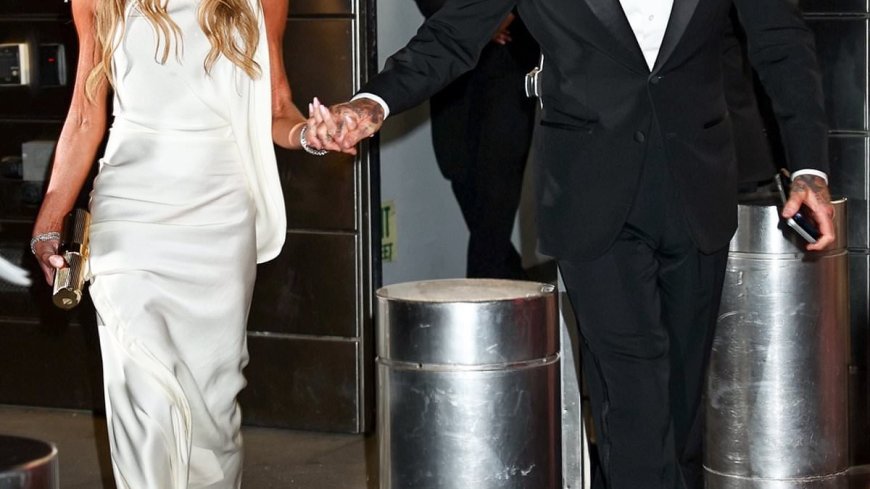 Victoria Beckham cuts an elegant display in a silk gown as she and husband David hold hands outside the TIME100 Gala in New York