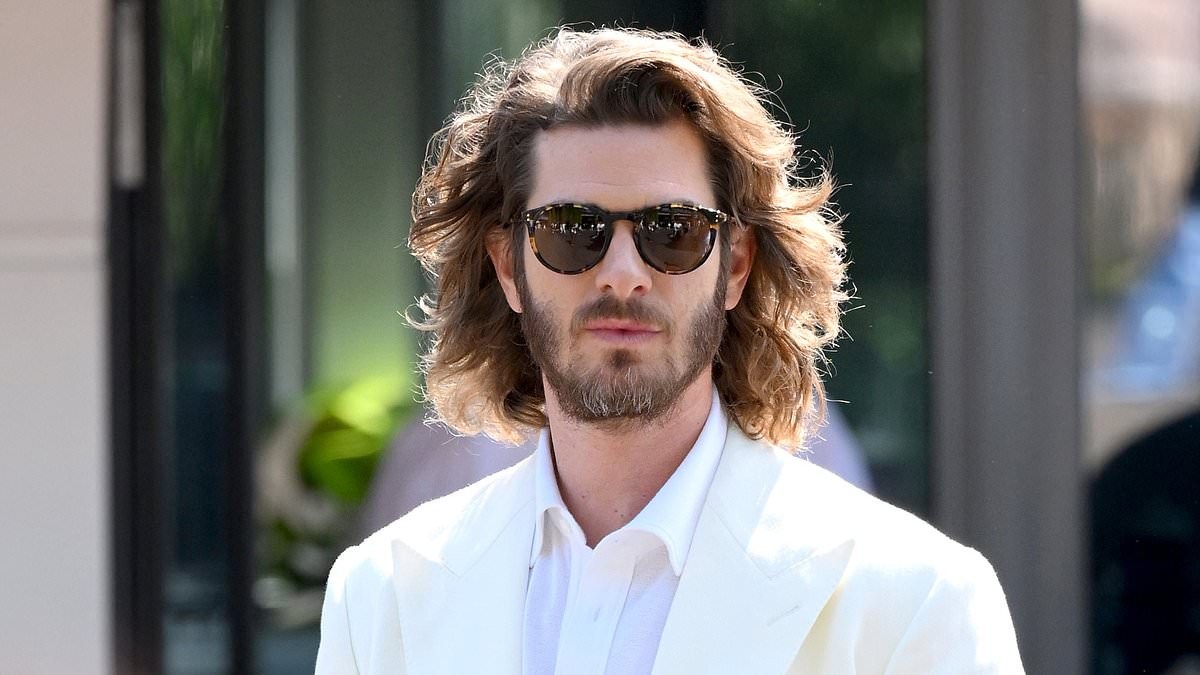 Andrew Garfield's wild long hair leaves him looking 'almost unrecognisable' at Wimbledon as he is overshadowed by Jennifer Lopez's huge hat