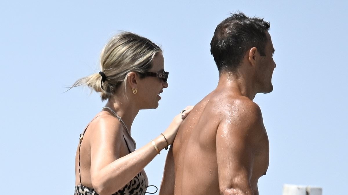 Pregnant Vogue Williams shows off her bump in a leopard print bikini as she enjoys a PDA with Spencer Matthews on the beach in Spain