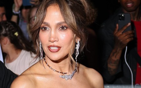 Jennifer Lopez dazzles in a low-cut feather-trim dress and glittering jewels as she attends Chopard party in Paris