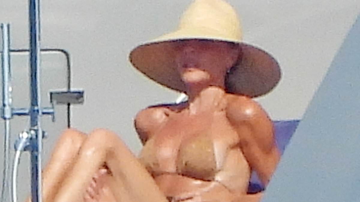 Victoria Beckham leaves little to the imagination in a nude bikini as she relaxes on her yacht in Italy with husband David