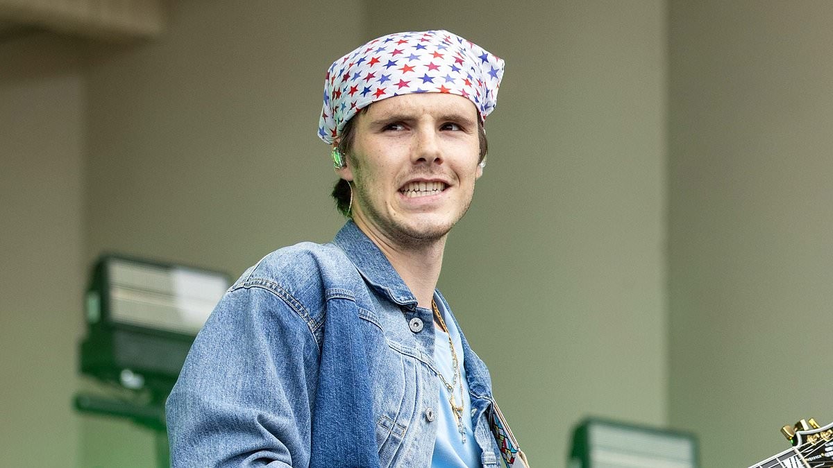 Cruz Beckham looks quirky in a headscarf and double denim as his band play first festival while his family holiday near his estranged brother Brooklyn in the South of France