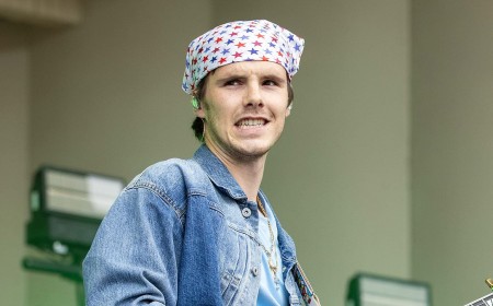 Cruz Beckham looks quirky in a headscarf and double denim as his band play first festival while his family holiday near his estranged brother Brooklyn in the South of France