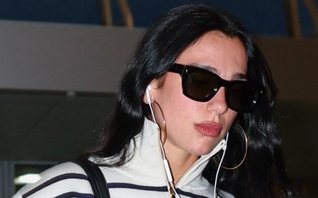 Dua Lipa nails riviera chic in stripes and jeans while making a statement with a VAST Chanel bucket bag as she jets out of JFK Airport