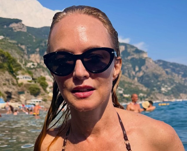 Heather Graham, 56, showcases her incredible figure in a maroon bikini as she frolics in the sea during sun-soaked Italian getaway