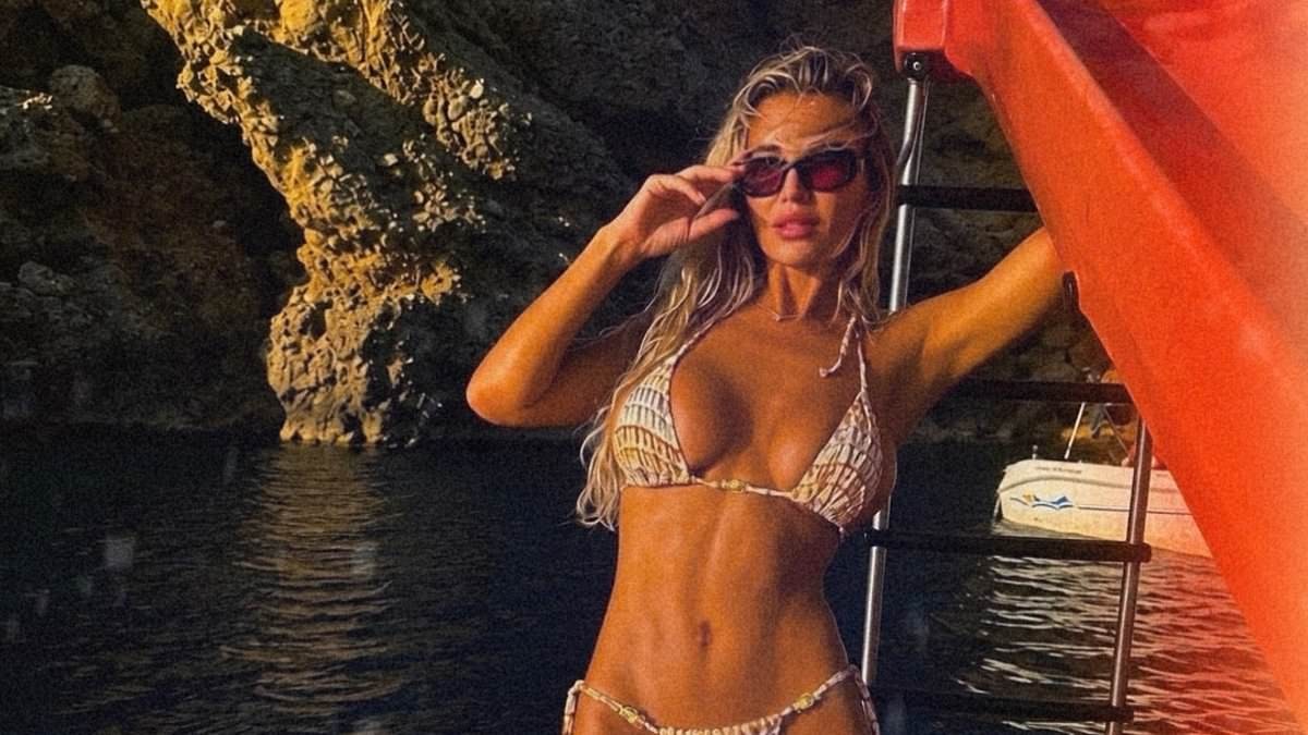 Christine McGuinness poses in her bikini on a pedalo boat on holiday as she escapes the London rain