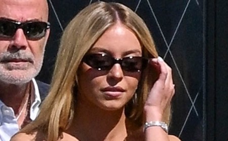 Sydney Sweeney slips into a white mini dress as she ropes her friend into being her social media manager during water taxi ride in Venice