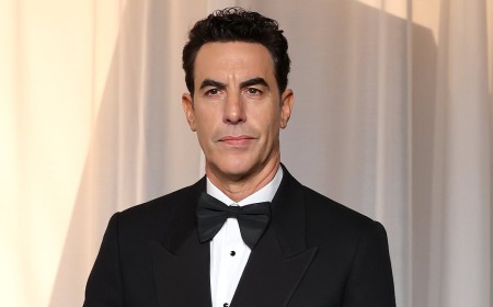Sacha Baron Cohen swaps Ali G's tracksuit for a tux as he risks run-in with ex Isla Fisher at Academy Museum Gala - amid criticism of controversial character's comeback